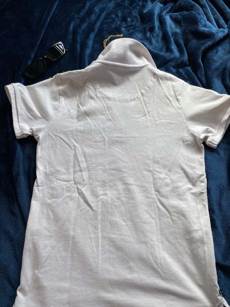 Regatta White Polo Shirt Essentials (Category: Tshirts & Polo Shirts ) located in Manila. Submitted by gabbuysells (Listing ID 1464892091, Image 2). Description: - Brand: Regatta Essentials - Size: Small - Color: White with navy and red collar stripes - Material: Cotton pique - Features: Short sleeves, classic collar, button placket, and small embroidered chest logo - Condition: Clean, excellent, and ready to wear.
