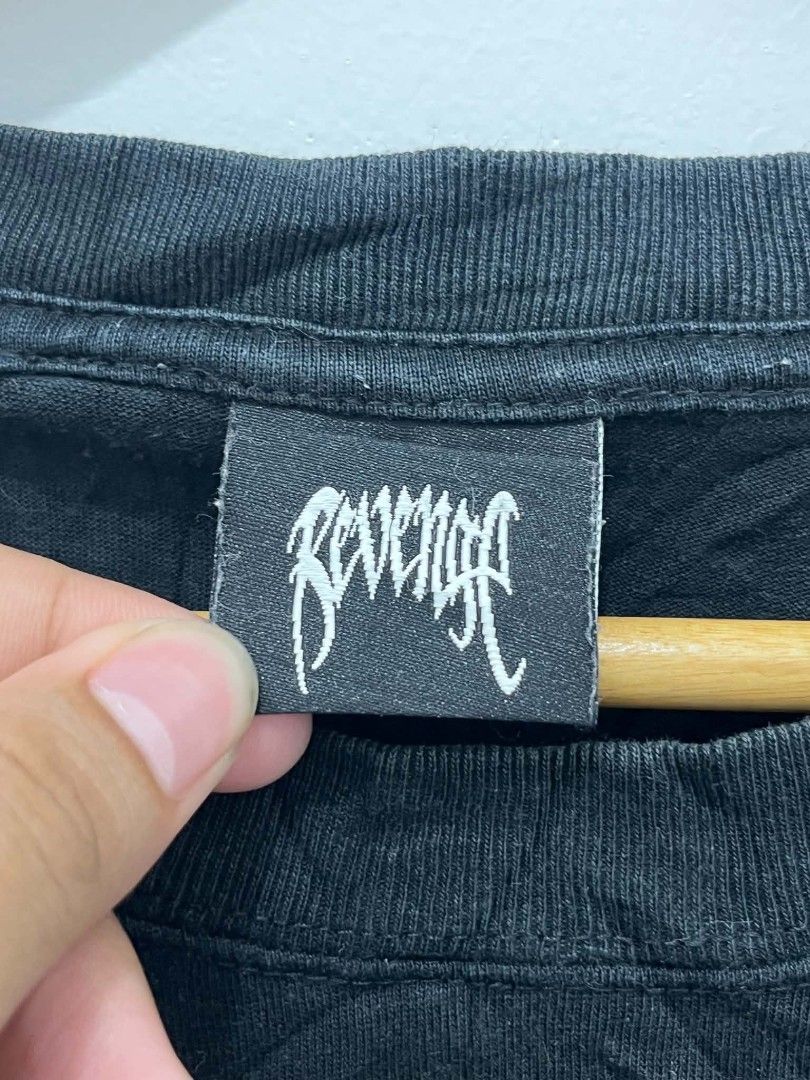 Revenge Bone Skull (Category: Tshirts & Polo Shirts ) located in Santa Rita. Submitted by papagabs01 (Listing ID 1464883236, Image 3). Description: Dimes 23x28 9.5/10 Color Rate ✨ Issue nasa dulo ng pic, hairline na sa back print No pinhole ‼️ - Brand: Revenge - Style: Classic streetwear graphic tee - Color: Black (with slight fade from wash and wear) - Size: XL - Design: White bone typography on chest, large screaming skull on back - Details: Ma