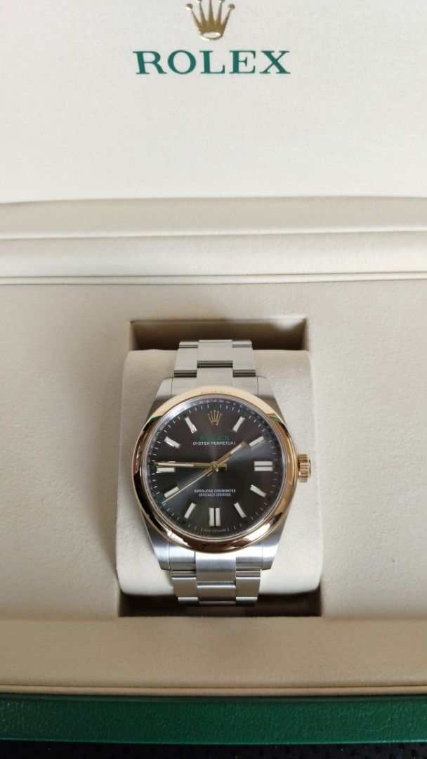 Rolex 100 Anniversary (Category: Luxury Watches) located in Manila. Submitted by epicmountain.05472a (Listing ID 1464791817, Image 1). Description: - Model: Rolex Oyster Perpetual - Material: Two-tone stainless steel and rose gold (Everose) - Dial: Dark grey sunburst with gold hour markers, hands, and distinctive green minute track - Bracelet: Iconic Oyster bracelet with polished center links - Inclusions: Original green presentation box and gree