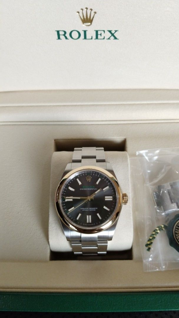 Rolex 100 Anniversary (Category: Luxury Watches) located in Manila. Submitted by epicmountain.05472a (Listing ID 1464791817, Image 3). Description: - Model: Rolex Oyster Perpetual - Material: Two-tone stainless steel and rose gold (Everose) - Dial: Dark grey sunburst with gold hour markers, hands, and distinctive green minute track - Bracelet: Iconic Oyster bracelet with polished center links - Inclusions: Original green presentation box and gree