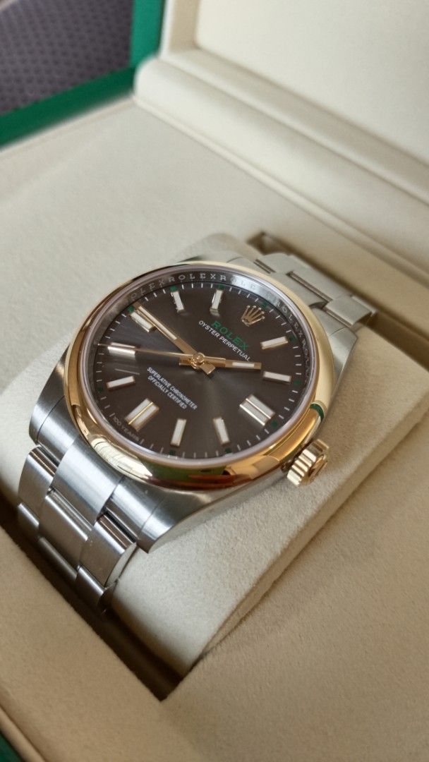 Rolex 100 Anniversary (Category: Luxury Watches) located in Manila. Submitted by epicmountain.05472a (Listing ID 1464791817, Image 2). Description: - Model: Rolex Oyster Perpetual - Material: Two-tone stainless steel and rose gold (Everose) - Dial: Dark grey sunburst with gold hour markers, hands, and distinctive green minute track - Bracelet: Iconic Oyster bracelet with polished center links - Inclusions: Original green presentation box and gree