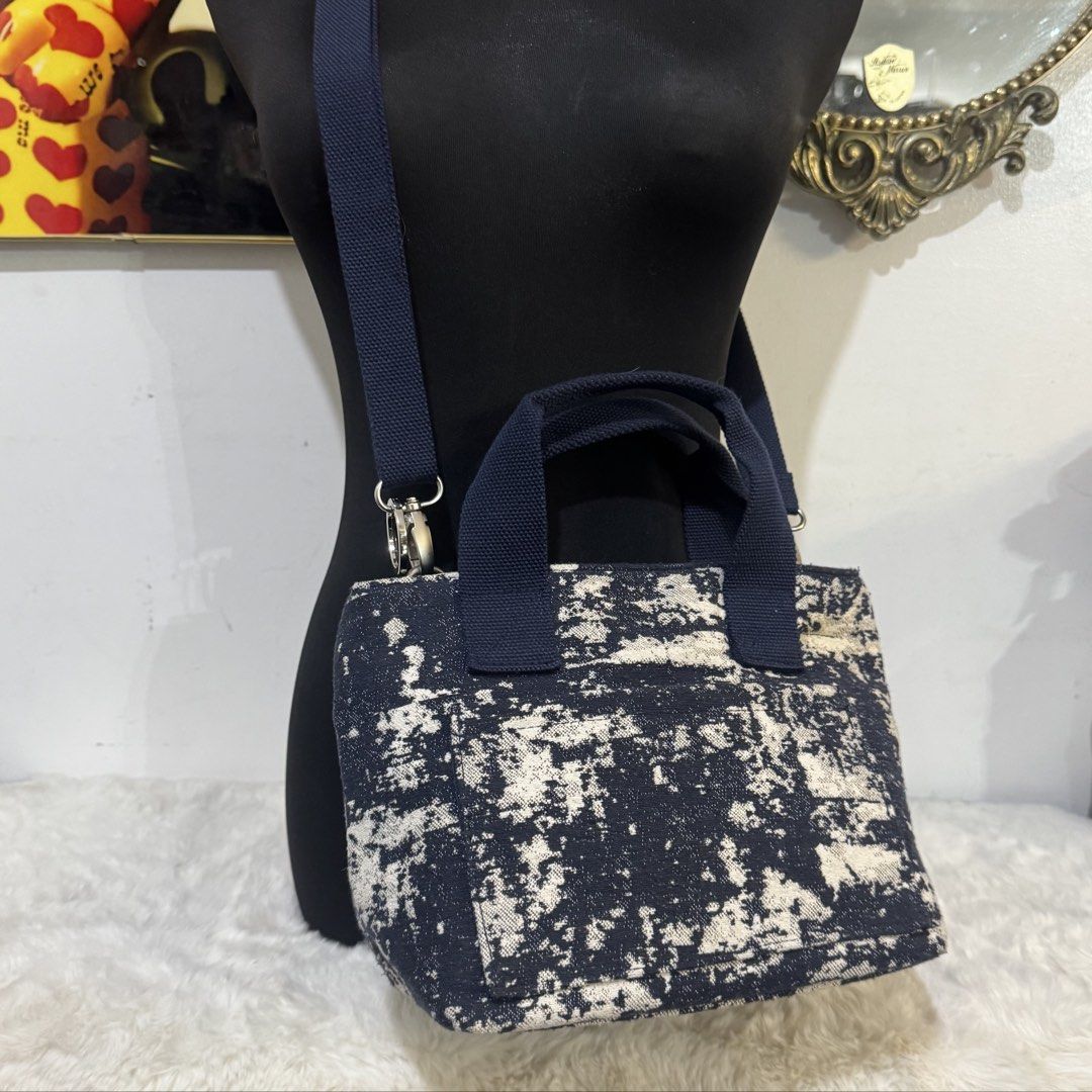 Rootote mini Tote Bag with Strap (Category: Tote Bags) located in Rizal. Submitted by houseofbell (Listing ID 1464947174, Image 3). Description: - Textured canvas tote with a trendy black and white abstract pattern - Dual navy blue top handles and an adjustable matching shoulder strap - Secure top zipper closure with metal hardware detail - Spacious interior with a clean fabric lining, perfect for daily essentials Excellent condition Likenew.