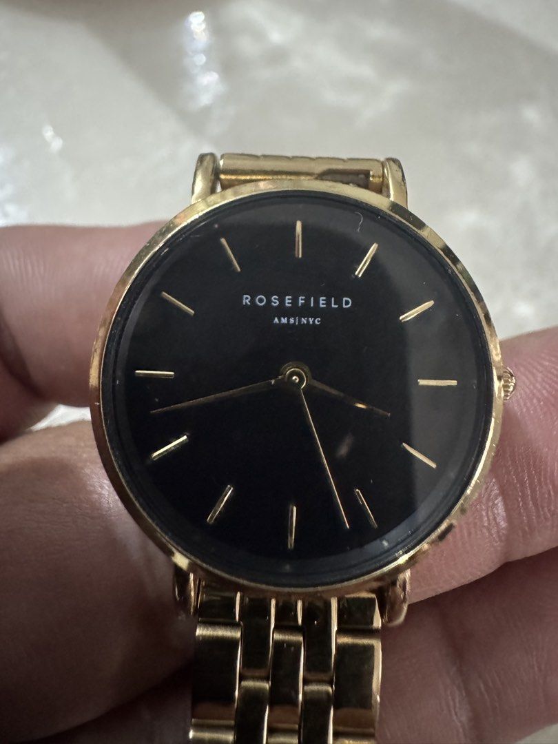 Rosefield Gold Watch with Black Dial (Category: Women's Watches) located in Cavite. Submitted by marcuz1316 (Listing ID 1464901194, Image 2). Description: - Brand: Rosefield - Color: Polished gold finish with a striking black dial - Design: Minimalist analog face with thin gold hour markers - Strap: Metal link bracelet - Inclusions: Original branded box and paper insert - Condition: Classic everyday timepiece in sleek condition.