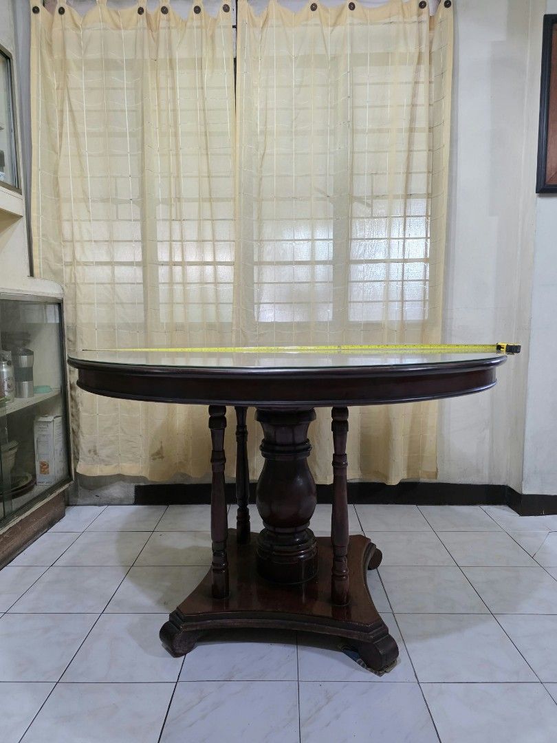 Round wooden dining table with pedestal base (Category: Tables & Sets) located in Quezon City. Submitted by bertlegaspi8 (Listing ID 1464901292, Image 2). Description: - Classic traditional round dining table, approx. 48 inches across - with glass and lasy susan turntable - Rich reddish-brown finish with a solid pedestal base, four columns, and curved feet - Heavy and sturdy construction, perfect for daily family meals and gatherings - Condition: