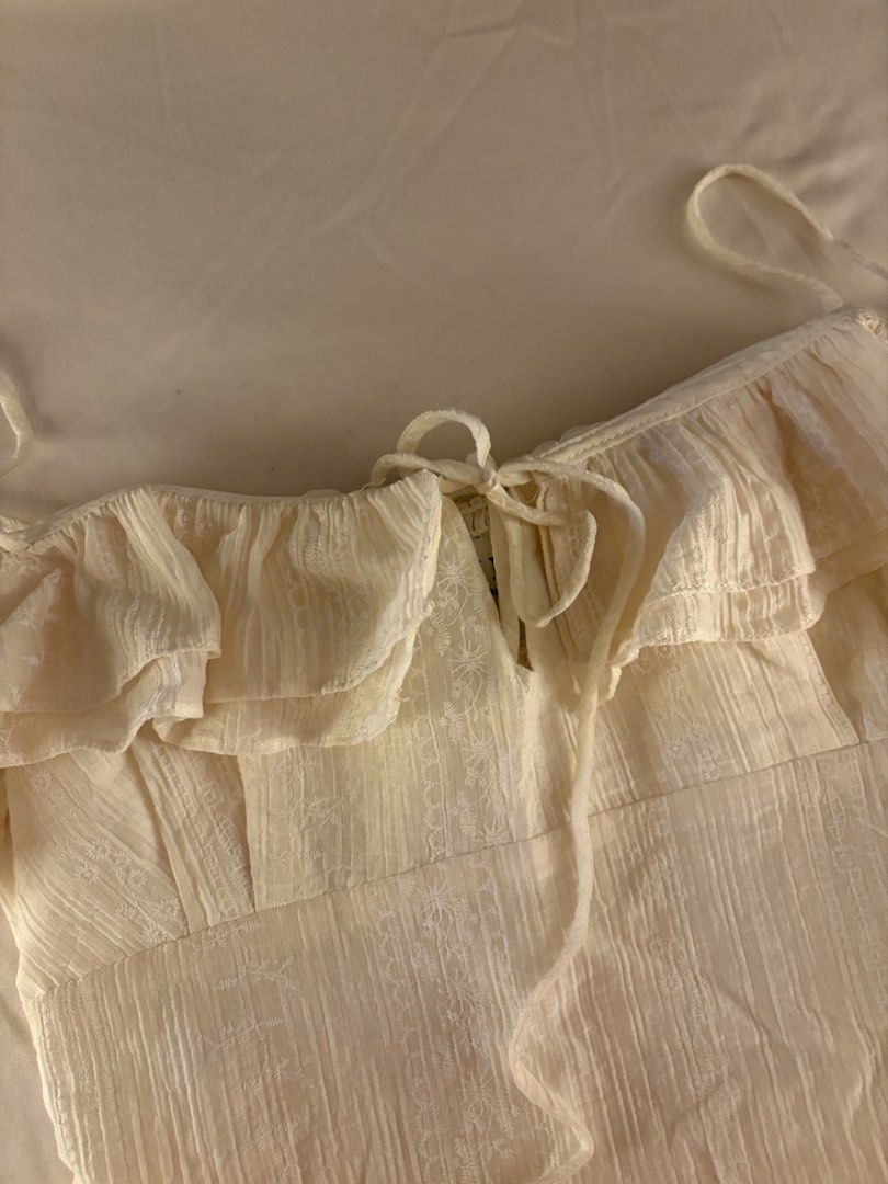 Rubies Saigon Ecru Cream Flowy Ruffled Smocked Top (Category: Sleeveless) located in Makati City. Submitted by chiclane_ (Listing ID 1464874064, Image 2). Description: pretty fabric! can be worn with the straps as cold shoulder top or off shoulder bought from rubies vietnam brand for reach only.