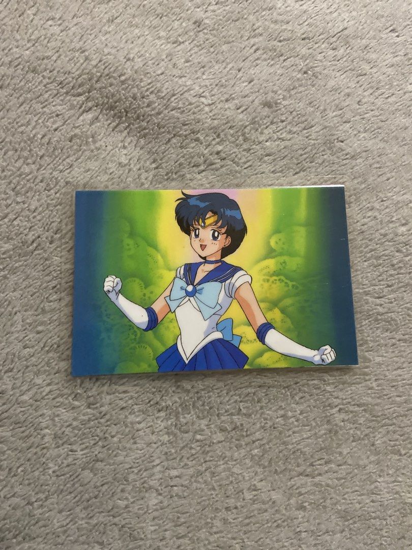 Sailor Mercury (Category: Raw Singles) located in Davao. Submitted by mengsmixitems (Listing ID 1464896083, Image 1). Description: - Authentic Sailor Moon R trading card featuring Sailor Mercury on the front - Reverse side displays silhouettes of all five Inner Senshi - Official Toei Animation licensing sticker and Seika Note branding - Manufactured in Japan by Movic - Standard card size, stored securely in a clear protective sleeve.