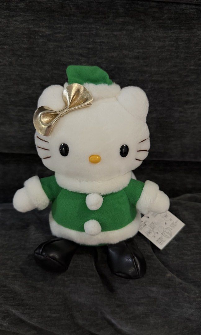 Sanrio Hello Kitty Christmas Plush (Category: Plushies & Soft Toys) located in Cabadbaran. Submitted by cinnamororr (Listing ID 1464961776, Image 1). Description: - Adorable Kitty plush dressed in a festive green - Features a sparkly gold bow on the ear, white collar, and black boots - Includes a cute white gift bag strapped to the back with yellow rope - Original tag still attached to the side - Clean fabric and bright, vibrant colors throughout