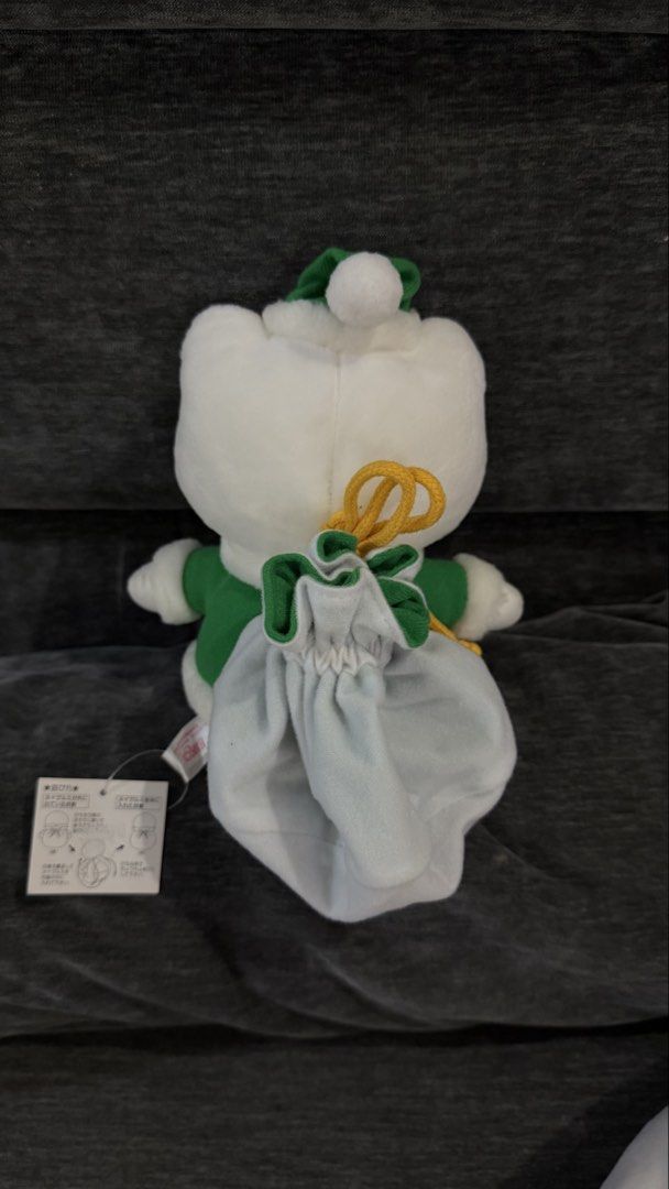 Sanrio Hello Kitty Christmas Plush (Category: Plushies & Soft Toys) located in Cabadbaran. Submitted by cinnamororr (Listing ID 1464961776, Image 3). Description: - Adorable Kitty plush dressed in a festive green - Features a sparkly gold bow on the ear, white collar, and black boots - Includes a cute white gift bag strapped to the back with yellow rope - Original tag still attached to the side - Clean fabric and bright, vibrant colors throughout