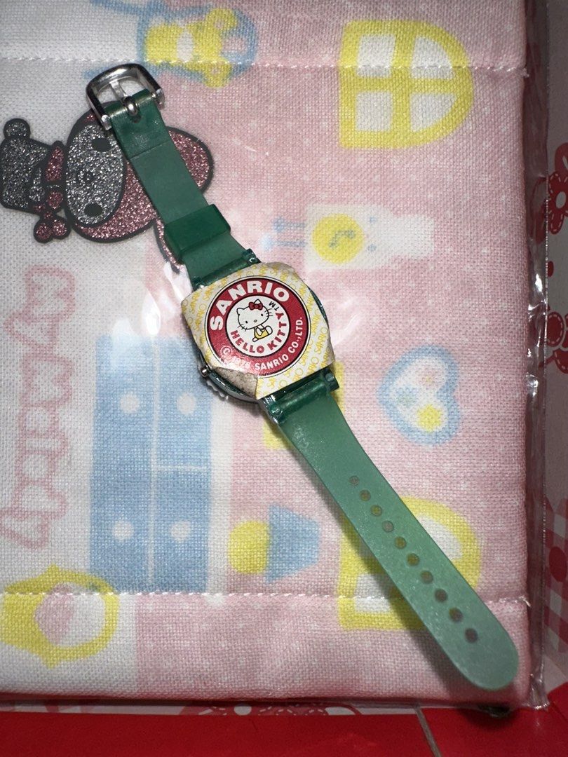 Sanrio Hello Kitty Vintage Watch Green Strap (Category: Women's Watches) located in Quezon City. Submitted by mitchapple88 (Listing ID 1464820200, Image 2). Description: - Authentic Sanrio collectible watch with 1976 copyright stamp - Features a cute 3D character figure in a red top on the front - Translucent green strap with an adjustable buckle closure - Original Kitty sticker seal still intact on the back casing - Fun and rare retro piece perf