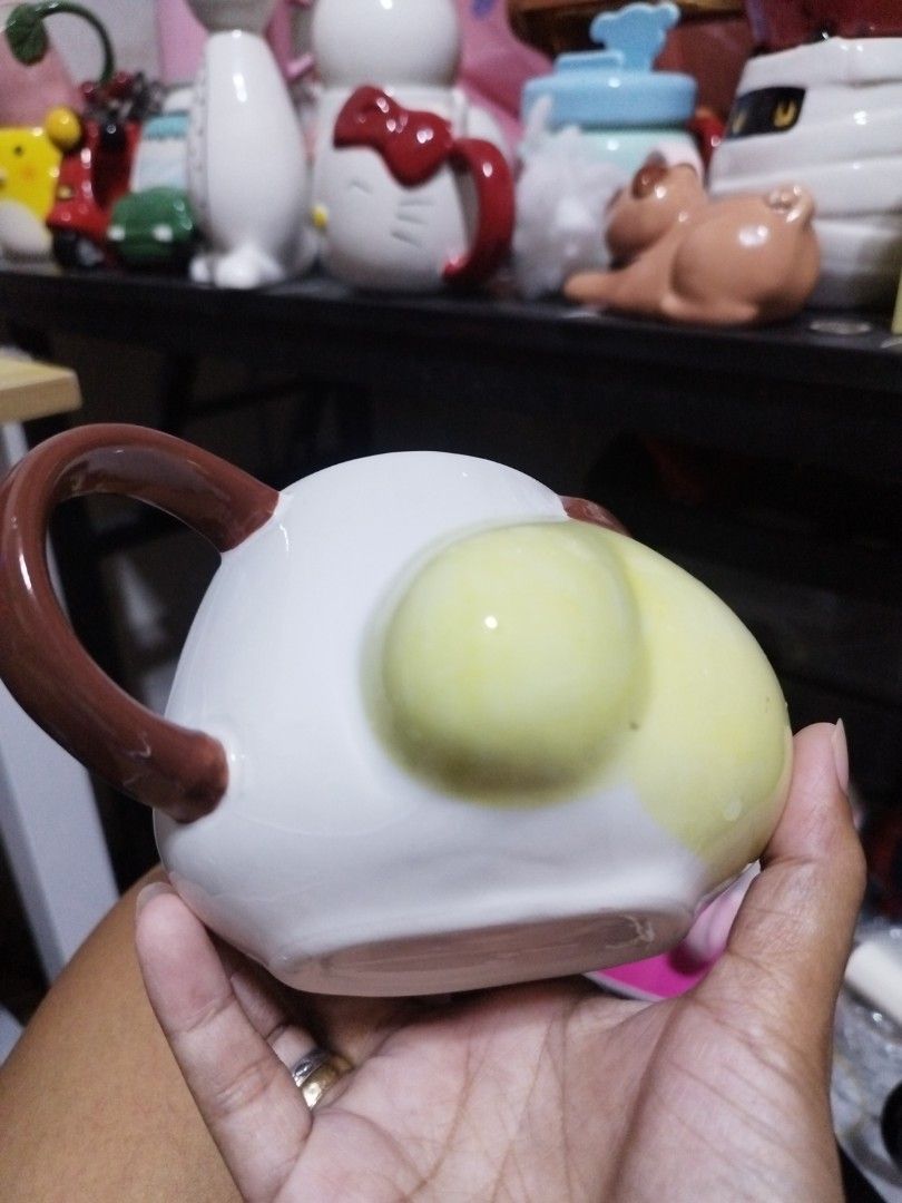 Sanrio Pompompurin ceramic mug with brown handle (Category: Coffee & Tea Tableware) located in Manila. Submitted by silverwhale_cafa21 (Listing ID 1464795025, Image 2). Description: - Authentic Pompompurin ceramic mug - Front design features Pompompurin's iconic yellow face with brown nose and mouth - Back features 'POMPOMPURIN' text and quote: 'Special days are to be enjoyed with special friends' - Accented with a cute brown handle on the side -