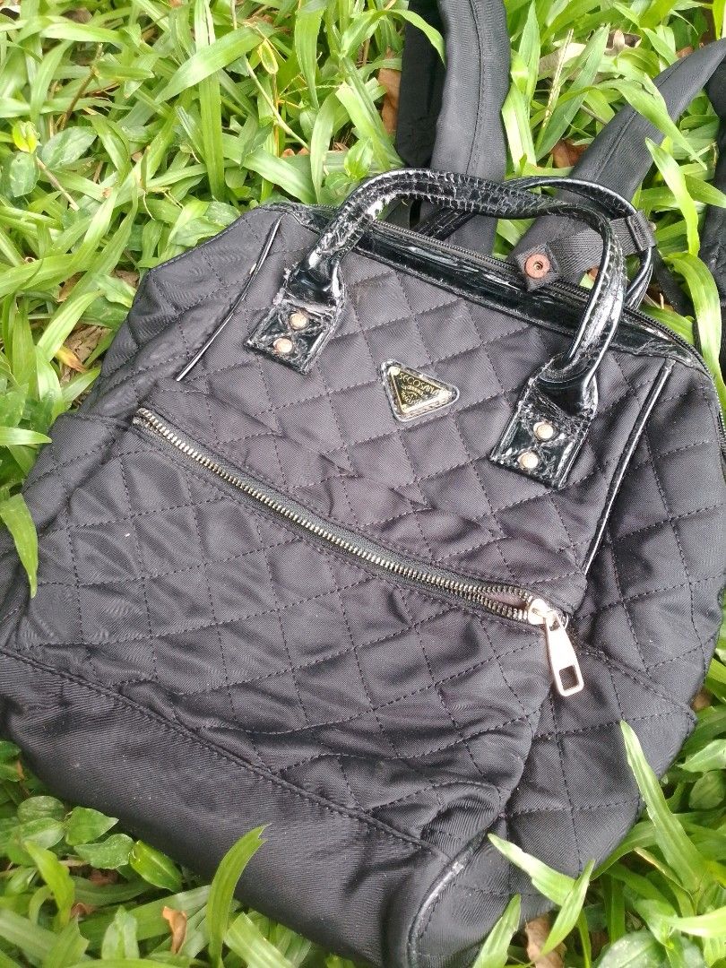 Secosana Black Quilted Backpack with Handles (Category: Backpacks) located in Tabaco. Submitted by cuniie (Listing ID 1464912956, Image 1). Description: - Brand: Secosana - Material: Durable black quilted nylon with shiny patent leather top handles - Features: Front zipped pocket, secure top zip closure, and adjustable back straps - Hardware & Logo: Elegant gold-tone hardware with a triangular Secosana metal logo plate - Condition: Shows some pee