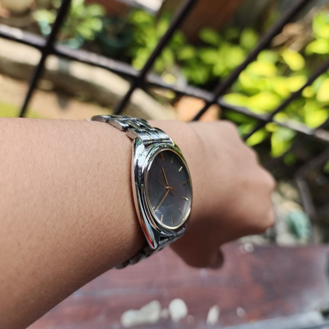 Seiko Lucent (Category: Women's Watches) located in Manila. Submitted by altlazo23 (Listing ID 1464923414, Image 3). Description: - Brand/Model: Seiko Lucent Classic Dress Watch - Dial: Dark grey dial with elegant gold hands and markers - Bracelet: Two-tone silver and gold standard links bracelet with a secure folding clasp - Design: Crown positioned on the right side - Condition: Clean crystal with minimal signs of wear on the case and band - St