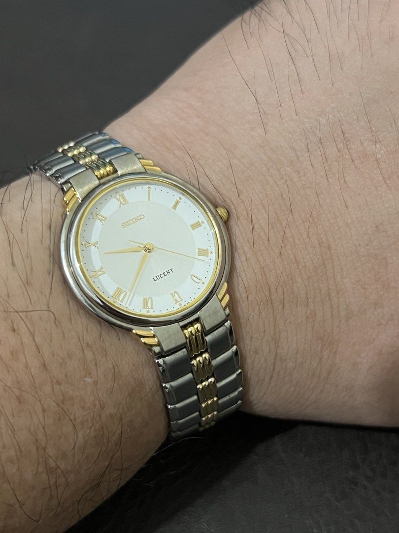 Seiko Lucent Two-Tone Roman Dial Quartz – Ref. 5E21-6C40 (Category: Men's Watches) located in Quezon City. Submitted by bobby.brown. (Listing ID 1464909309, Image 3). Description: Seiko Lucent Two-Tone Roman Dial Quartz – Ref. 5E21-6C40 Estimated BMBY: May 1993 A refined classic dress watch from Seiko’s Lucent line, featuring a polished round base metal case highlighted by gold-tone accents and a cabochon-tipped crown. The light silver sector dia