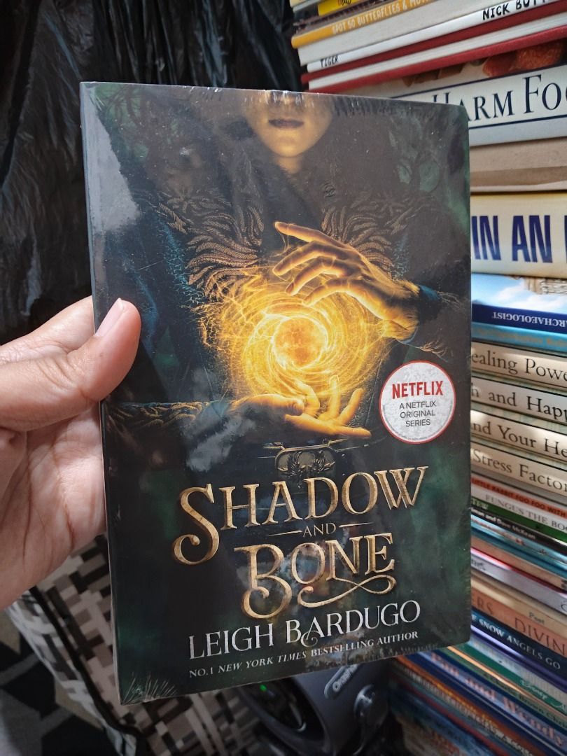 Shadow and Bone by Leigh Bardugo Paperback (Category: Storybooks) located in Taguig. Submitted by jener.498 (Listing ID 1464925898, Image 1). Description: - Title: Shadow and Bone by Leigh Bardugo - Edition: Orion publishing with Netflix series sticker - Condition: Brand new, still sealed in original plastic wrap - Status: Unopened and unused.