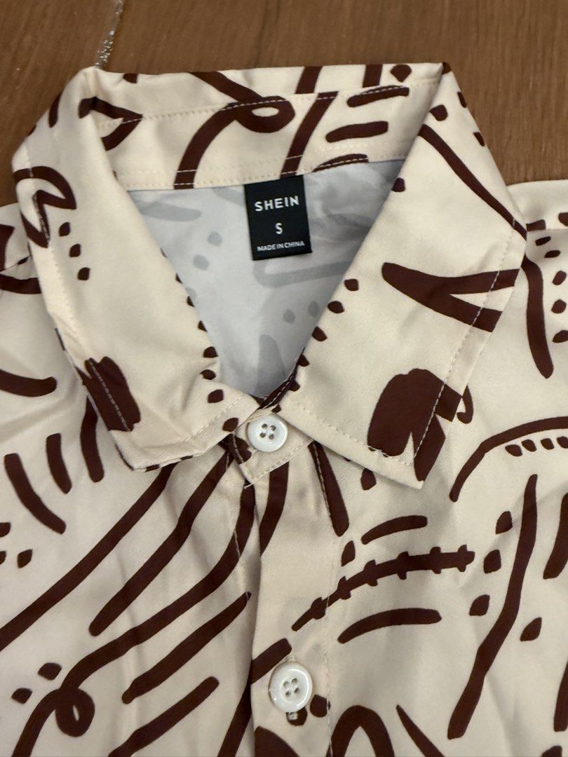 SHEIN Abstract Print Shirt and Solid Shorts Set Size S (Category: Sets & Coordinates) located in Bulacan. Submitted by emjay_17 (Listing ID 1464890672, Image 3). Description: - Brand: Shein - Size: Small (Brand new with tags!) - Top: Short-sleeve button-down shirt with a brown abstract doodle pattern on off-white - Bottoms: Solid dark brown shorts with an elasticated waistband and black drawstring - Material: Lightweight and breathable, ideal for