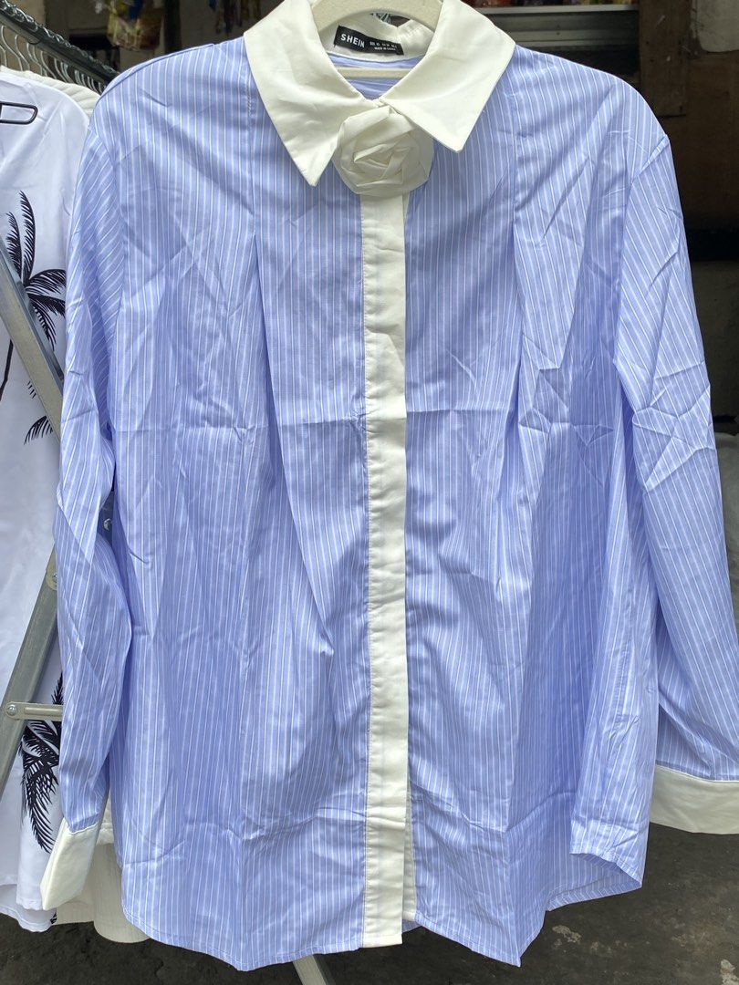 SHEIN Blue and White Striped Collared Shirt (Category: Shirts) located in Pateros City. Submitted by shin_0221 (Listing ID 1464796561, Image 1). Description: - Brand: SHEIN - Design: Blue and white stripes with contrasting white collar, placket, and cuffs - Unique Detail: Built-in fabric rose right on the collar - Fit: Relaxed fit, long sleeves, button-front closure - Xs on tag but fit to M to L - Fabric: Lightweight and comfortable - Style: Smar