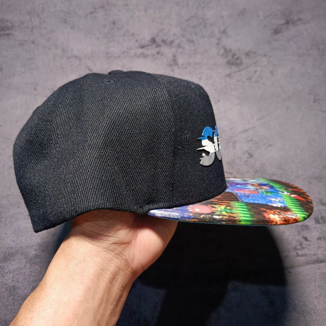 Sonic the Hedgehog Snapback Cap Spencer's Exclusive (Category: Caps & Hats) located in Manila. Submitted by nye.seller (Listing ID 1464886065, Image 2). Description: - Item: Sonic the Hedgehog Snapback Cap - Color: Black with bright blue under brim - Details: Raised Sonic text logo and colorful Green Hill Zone pixel art print on brim - Fit: Adjustable plastic snap closure in the back - Condition: Brand new with Spencer's store tag attached, never