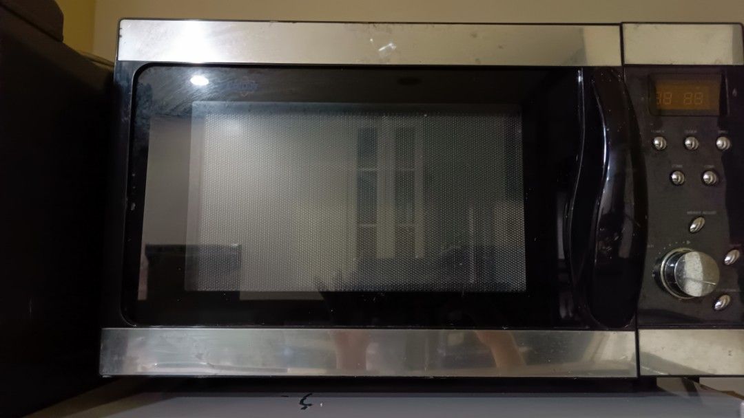 Stainless Steel Microwave with Handle and Digital Display (Category: Ovens & Toasters) located in San Juan City. Submitted by pinkdenxel (Listing ID 1464900209, Image 1). Description: - Type: Stainless steel countertop microwave - Features: Digital clock display, multi-control buttons, side dial, and glass turntable - Design: Black finish body with stylish stainless steel trim and handle door mechanism - Power: Standard plug (tested and powers on