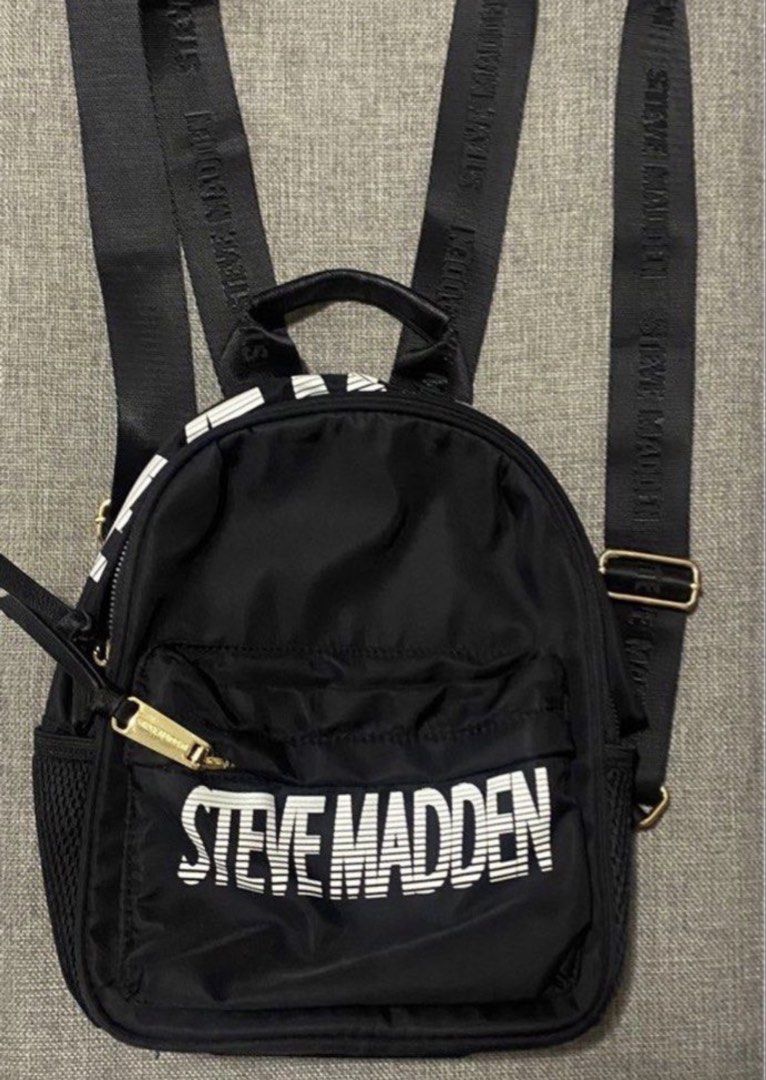 Steve Madden backpack (Category: Backpacks) located in Manila. Submitted by bwshoppe (Listing ID 1464915237, Image 1). Description: STEVE MADDEN black backpack (small size) with 1 zip pocket infront, 1 zip pocket back, 1 inner zip pocket & 2 inner slip on pockets Made of Nylon similar to longchamp fabric texture (water repellant)& light to carry. Purchased in US Outlet Mall . .