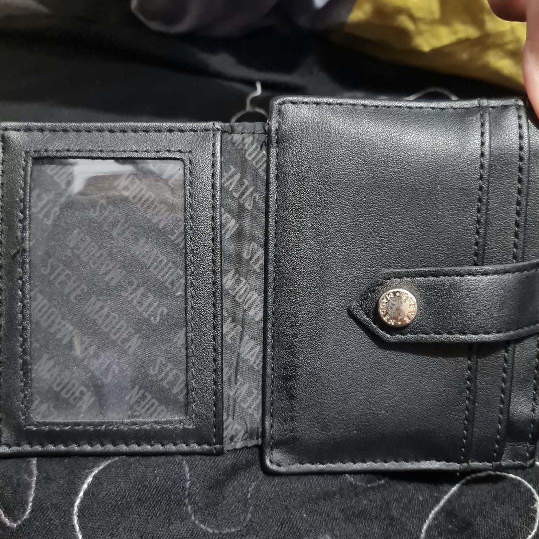 Steve Madden Black Card Holder Wallet (Category: Wallets & Card holders) located in San Juan City. Submitted by janine_0791 (Listing ID 1464904149, Image 2). Description: - Brand: Steve Madden - Color: Classic Black with chic gold-tone hardware - Storage: Multiple card slots, clear ID window, and secure top zipper compartment - Branding: Features an embossed logo on the front and a metallic plaque on the back - Design: Compact size that easily fi