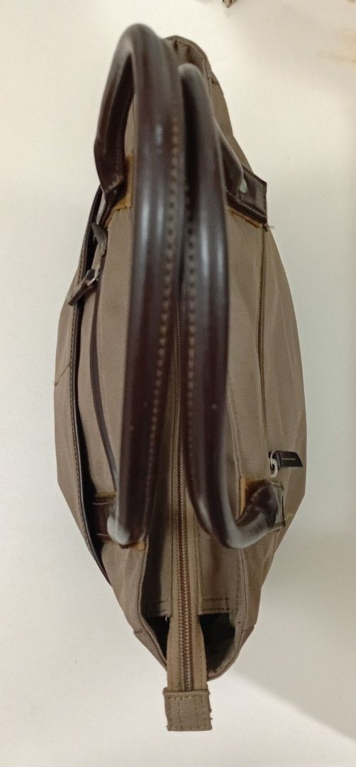 Structured Canvas & Rolled leather handle Everyday Tote Bag (Category: Tote Bags) located in Navotas City. Submitted by ms.soulana (Listing ID 1464795448, Image 3). Description: - Brand: NafNaf - Material: Durable brown canvas with dark brown leather handles and trim - Closure: Secure top zipper closure - Pockets: Front zip pocket and open slip pocket for easy access - Interior: Clean lining with a roomy interior that easily fits daily essentials