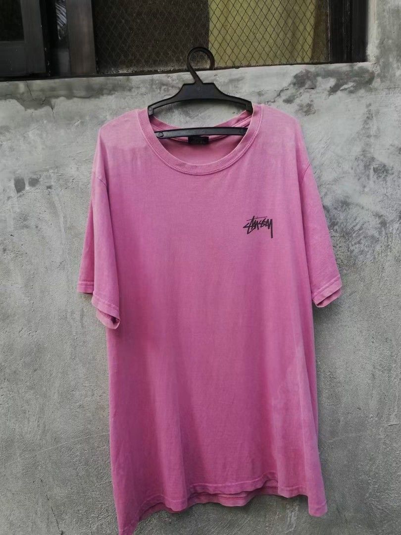 Stussy Pink Graphic Tee Size M (Category: Tshirts & Polo Shirts ) located in Manila. Submitted by kiraaaaaaaaaaa (Listing ID 1464838783, Image 3). Description: - Brand: Stussy - Size: Medium - Color: Pink - Material: 100% cotton, made in Mexico - Design: Small front chest logo with a large Africa graphic, Rastafari colors, and text print on the back - Fit: Regular fit, ideal for casual streetwear - Care: Wash care instructions printed inside the 