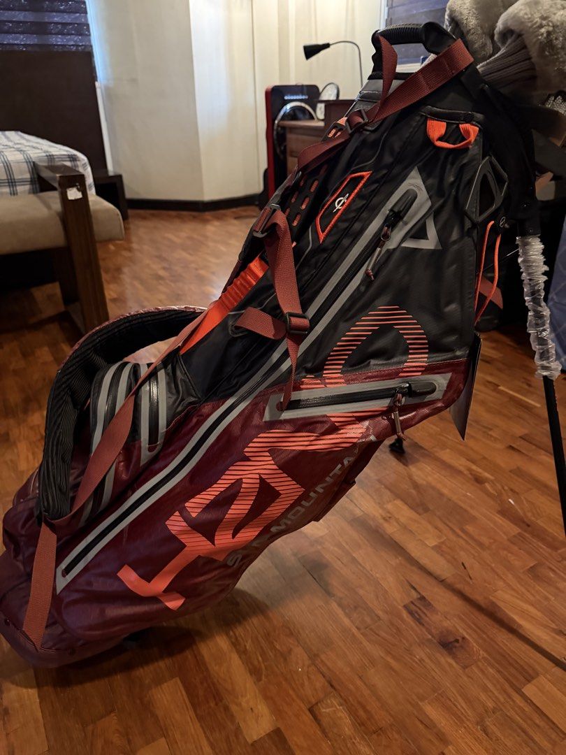 Sun Mountain Golf Bag (Category: Golf) located in Marikina City. Submitted by studiogammo (Listing ID 1464774686, Image 2). Description: - Brand: Sun Mountain H2NO Lite Stand Bag - Colorway: Black, Garnet, and Inferno - Condition: Brand new with original hang tag attached and plastic wrapping still on stand legs - Waterproof: Fully waterproof construction with sealed taped zippers - Storage: Multiple zippered pockets for apparel and gear - Comfor