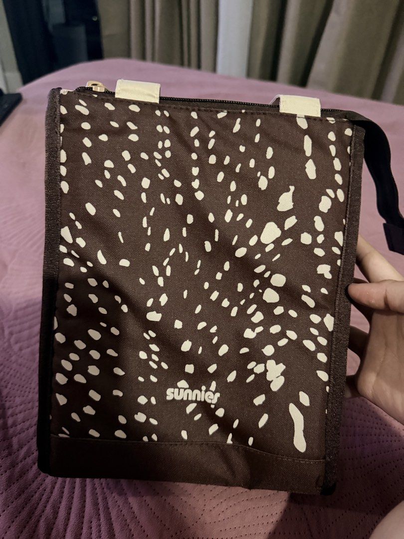 Sunnies Studios Daily Lunch Pack in Bambi (Category: Tote Bags) located in Cebu City. Submitted by medicalcookie (Listing ID 1464774408, Image 3). Description: - Brand: Sunnies Studios - Style: Daily lunch pack in Bambi print (brown with white abstract spots) - Interior: Insulated silver foil lining to keep food warm or cold - Features: Top zipper closure and cream-colored carry handles - Condition: Brand new, still sealed in original plastic pac