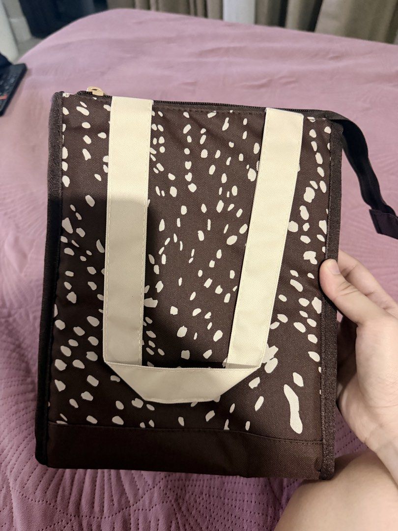 Sunnies Studios Daily Lunch Pack in Bambi (Category: Tote Bags) located in Cebu City. Submitted by medicalcookie (Listing ID 1464774408, Image 2). Description: - Brand: Sunnies Studios - Style: Daily lunch pack in Bambi print (brown with white abstract spots) - Interior: Insulated silver foil lining to keep food warm or cold - Features: Top zipper closure and cream-colored carry handles - Condition: Brand new, still sealed in original plastic pac