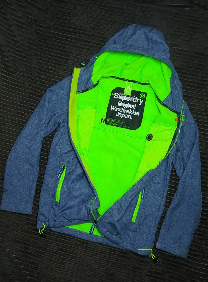 Superdry Original Windtrekker Japan Jacket Size M (Category: Coats, Jackets and Outerwear) located in Manila. Submitted by norathrifted (Listing ID 1464800987, Image 3). Description: - Authentic Superdry Original Windtrekker Japan jacket - Color: Stylish blue marl with striking neon green fleece lining and matching zippers - Size: Men's Medium (M) - Features an attached hood with adjustable drawstrings - Secure storage with front zip pockets and 