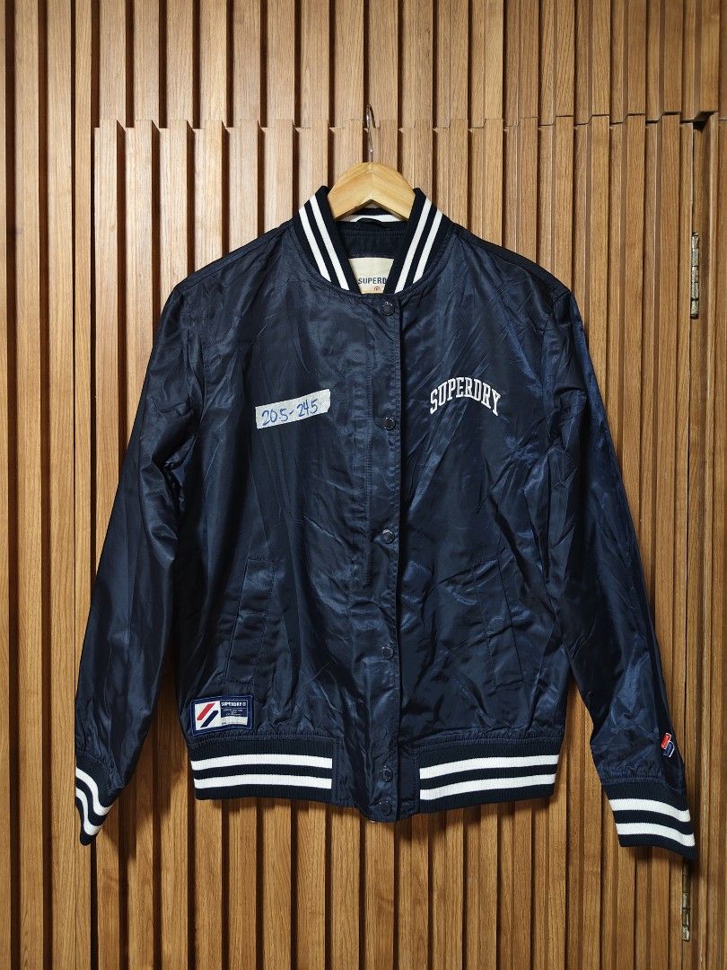 SUPERDRY VARSITY JACKET (Category: Coats, Jackets and Outerwear) located in San Fernando. Submitted by SungkiThrift (Listing ID 1464800119, Image 1). Description: 🔥 FOR SALE — SUPERDRY VARSITY JACKET 🔥 🖤 Navy Blue Superdry jacket ✨ Classic varsity/bomber style 🏷️ Superdry embroidered details & patches 📏 Measurements: 20.5" pit-to-pit × 24.5" length 🧥 With pockets, snap buttons & striped ribbed cuffs 👌 Good condition — minimal signs of use,