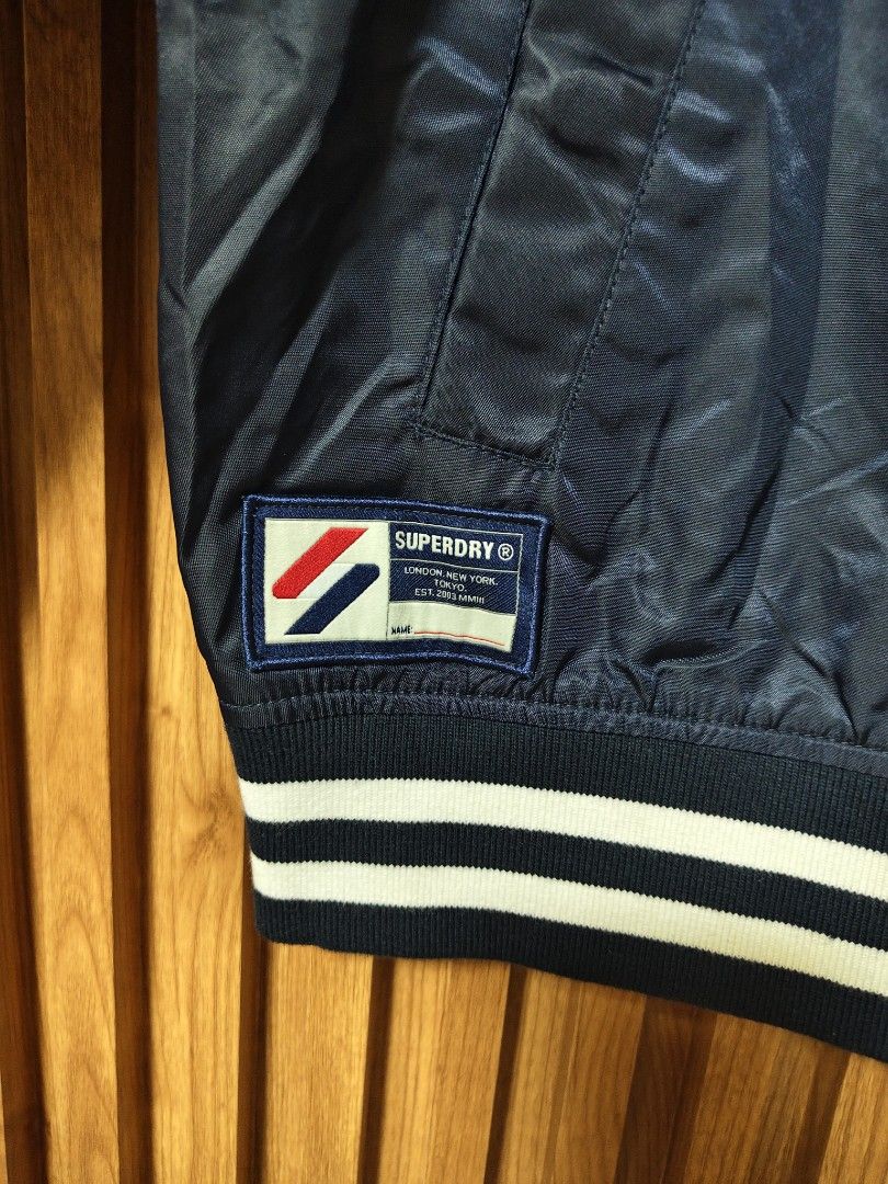 SUPERDRY VARSITY JACKET (Category: Coats, Jackets and Outerwear) located in San Fernando. Submitted by SungkiThrift (Listing ID 1464800119, Image 2). Description: 🔥 FOR SALE — SUPERDRY VARSITY JACKET 🔥 🖤 Navy Blue Superdry jacket ✨ Classic varsity/bomber style 🏷️ Superdry embroidered details & patches 📏 Measurements: 20.5" pit-to-pit × 24.5" length 🧥 With pockets, snap buttons & striped ribbed cuffs 👌 Good condition — minimal signs of use,