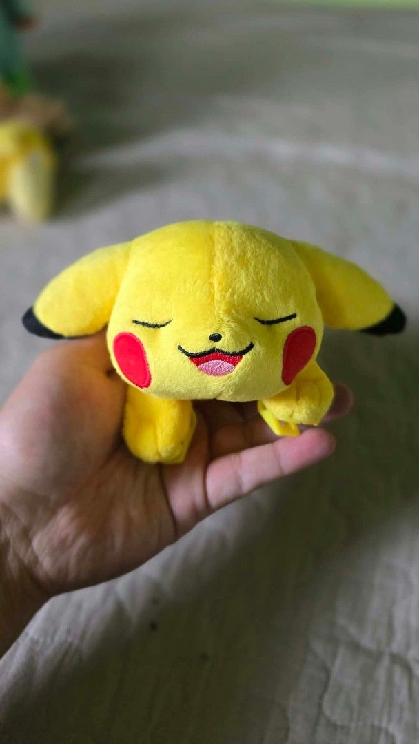Takara Tomy Sleeping Pikachu Pokémon Plush Toy (Category: Plushies & Soft Toys) located in Baguio. Submitted by je_ver_lyn16 (Listing ID 1464844801, Image 1). Description: - Official Takara Tomy Sleeping Pikachu plush - Features bright yellow fabric, embroidered face, and classic lightning tail - Equipped with hard plastic clips on the front paws for easy attachment - Clean fur and kept in a smoke-free home - Tag attached, perfect for collectors.