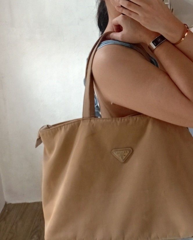 Tan Prad1a Nylon Tote Shoulder Bag (Category: Luxury Bags & Wallets) located in Navotas City. Submitted by ms.soulana (Listing ID 1463275190, Image 2). Description: PreOwned Lightly Used Tan Prada Tote Shoulder Bag Medium -Large Min Sign of Used Clean innerlining - Durable Nylon Material with Leather Trim - Secure Zipper Closure - Spacious Interior - Ideal for Everyday or Travel - Still a functional Flaws :( Staples )Check last Posted Picture reg