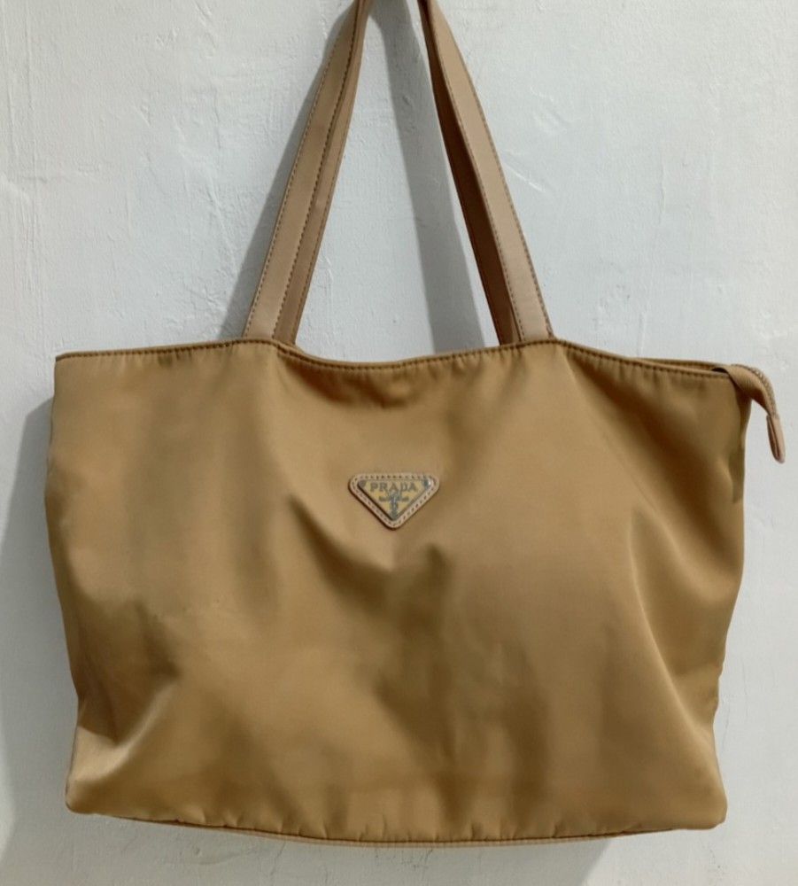 Tan Prad1a Nylon Tote Shoulder Bag (Category: Luxury Bags & Wallets) located in Navotas City. Submitted by ms.soulana (Listing ID 1463275190, Image 1). Description: PreOwned Lightly Used Tan Prada Tote Shoulder Bag Medium -Large Min Sign of Used Clean innerlining - Durable Nylon Material with Leather Trim - Secure Zipper Closure - Spacious Interior - Ideal for Everyday or Travel - Still a functional Flaws :( Staples )Check last Posted Picture reg