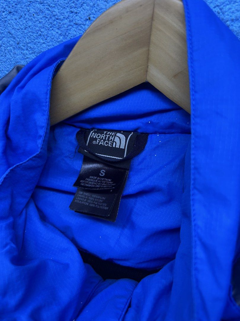 The North Face Blue Hooded Waterproof Jacket Size S (Category: Coats, Jackets and Outerwear) located in Quezon City. Submitted by thriftxgoods (Listing ID 1464898032, Image 2). Description: - Brand: The North Face - Color: Bright blue with grey lining - Size: Small (S) - Material: 100% nylon shell with polyester lining and insulation - Features: Waterproof, attached hood with drawstrings, zip closure with button flap - Pockets: Zippered chest and