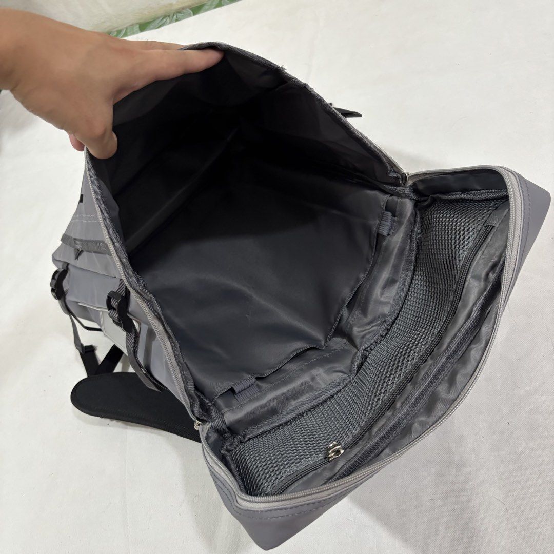 The North Face Grey Waterproof Backpack (Category: Backpacks) located in Cavite. Submitted by itsayaaa (Listing ID 1464839029, Image 3). Description: - Brand: The North Face - Color: Grey with large vertical front logo - Material: Durable, weather-resistant fabric - Storage: Wide-opening main compartment with internal divider sleeve and mesh zipper pocket - Comfort & Fit: Sturdy black shoulder straps with secure chest buckles - Extras: Multiple e