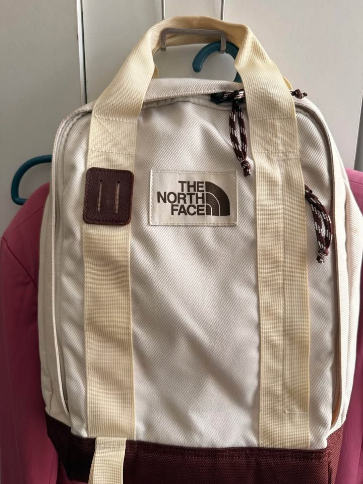 The North Face Off White Brown Tote Pack (Category: Backpacks) located in Caloocan City. Submitted by clemg6 (Listing ID 1464784758, Image 1). Description: - Color & Material: Off-white canvas with a durable brown bottom panel - Closure: Double zip top closure with stylish patterned pull cords - Versatile Carry: Features dual top carrying handles and adjustable shoulder straps - Storage: Classic rectangular shape with a roomy interior compartment
