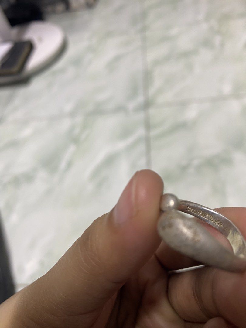 Tiffany & Co. Sterling Silver Bean Ring (Category: Rings) located in Pasacao. Submitted by wengpullar37205 (Listing ID 1464924027, Image 3). Description: - Brand: Tiffany & Co. - Design: Curved bean wrapping around the finger - Material: Sterling Silver (925 hallmark stamped inside band) - Size: US 6 (verified on mandrel) - Weight: 6.76 grams (verified on digital scale) - Condition: Excellent, 100% authentic -palinisan or papolish nio nlng po.