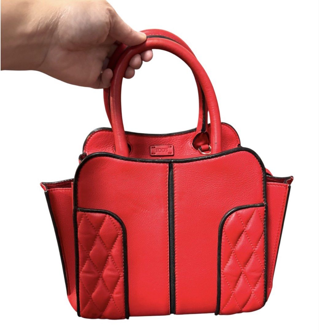 Tod's Red Leather Handbag (Category: Tote Bags) located in Baguio. Submitted by pwz-eshop (Listing ID 1464826470, Image 2). Description: • Please take time to read. • I do not have when worn pictures, please rely on actual dimensions for sizing. • Up for Grabs!! • Guaranteed Authentic!! • Flaws: Missing sling. Rubs on pipings. Scraped off leather edges on handles. Minor stains. (please see photos) • BRAND: Tod's. • DIMENSIONS: length 12", height 