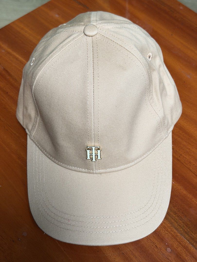 Tommy Hilfiger baseball cap (Category: Caps & Hats) located in Iloilo. Submitted by caratdeul.17 (Listing ID 1464794709, Image 1). Description: - Brand: Tommy Hilfiger - Color: Cream - Material: Cotton twill - Details: Embroidered flag logo on front, curved brim with tonal stitching - Fit: Adjustable strap at the back - Condition: Clean inside and out, ready to wear.