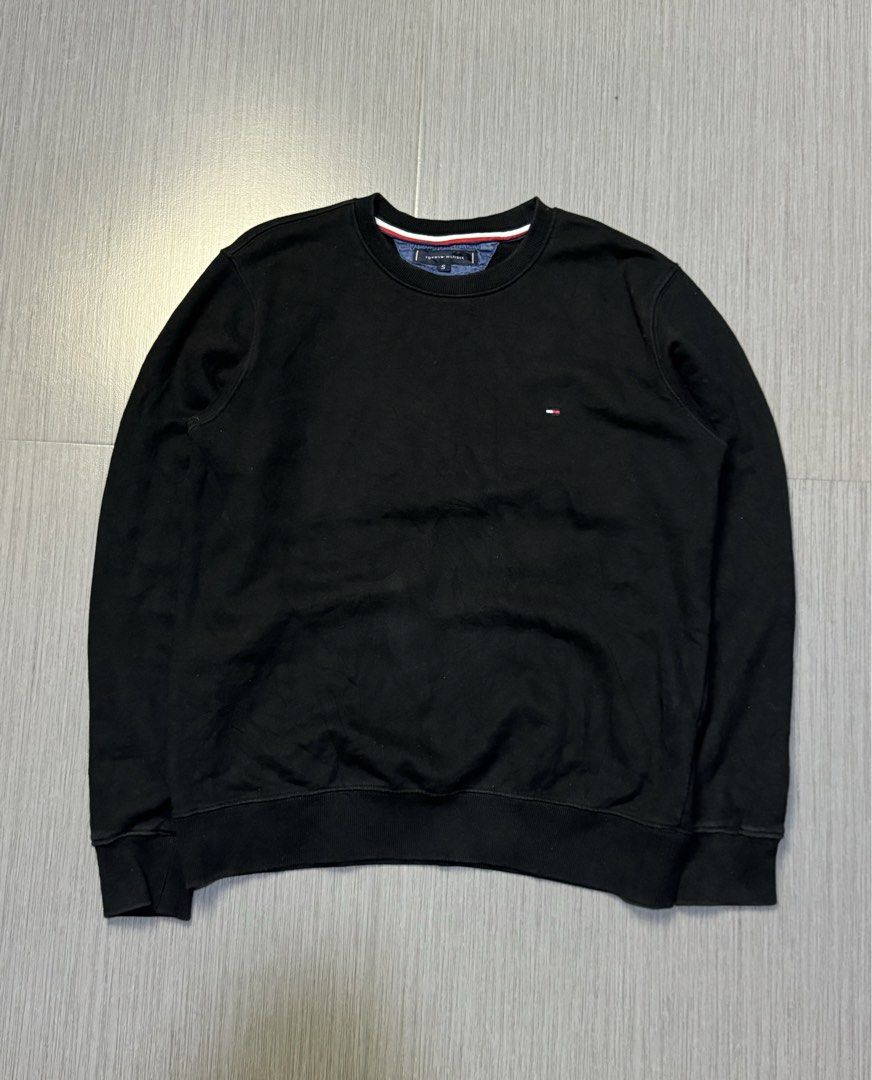 Tommy Hilfiger Black Sweatshirt Size S (Category: Coats, Jackets and Outerwear) located in Caloocan City. Submitted by mzcollection_349 (Listing ID 1464886098, Image 1). Description: - Brand: Tommy Hilfiger - Style: Crewneck Sweatshirt - Color: Solid Black - Size: S (Pit-to-pit: 21.5", Length: 27.5") - Details: Iconic embroidered logo on left chest, ribbed collar/cuffs/hem, striped trim tape inside neckline - Material: Soft and clean fleece fabri