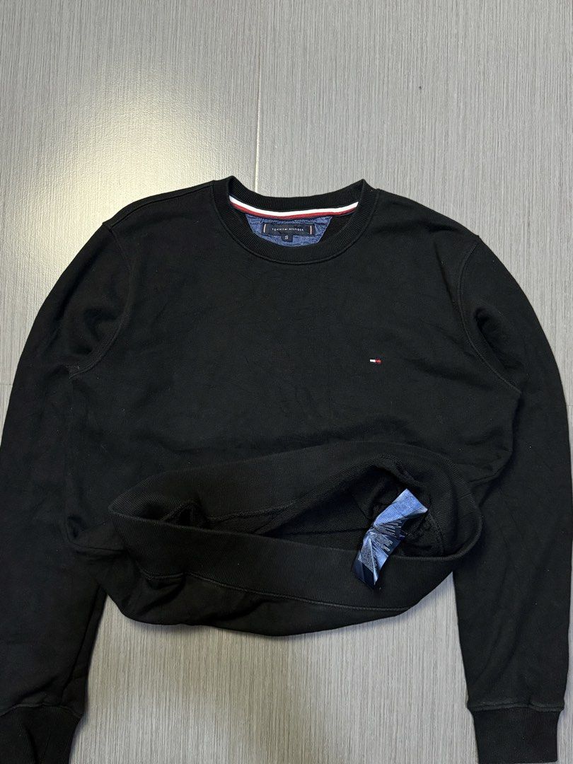 Tommy Hilfiger Black Sweatshirt Size S (Category: Coats, Jackets and Outerwear) located in Caloocan City. Submitted by mzcollection_349 (Listing ID 1464886098, Image 2). Description: - Brand: Tommy Hilfiger - Style: Crewneck Sweatshirt - Color: Solid Black - Size: S (Pit-to-pit: 21.5", Length: 27.5") - Details: Iconic embroidered logo on left chest, ribbed collar/cuffs/hem, striped trim tape inside neckline - Material: Soft and clean fleece fabri
