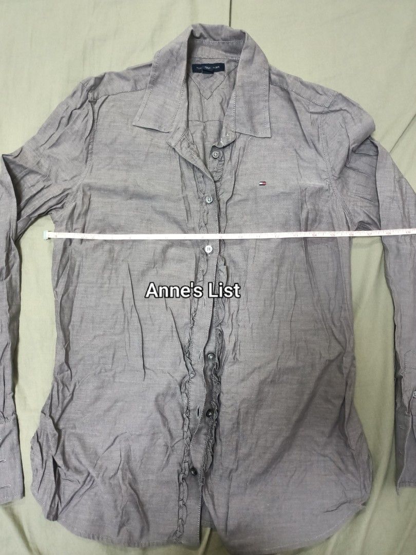 Tommy Hilfiger Ruffled Button-Down Shirt Size S-M (Category: Blouses) located in Santa Maria. Submitted by anne_s.list (Listing ID 1464831882, Image 3). Description: - Brand: Tommy Hilfiger - Style: Long sleeve button-down with front ruffle detail and classic collar - Color: Greyish-brown - Material: 100% Cotton - Fit/Sizing: Chest width measures 16 inches (model is 5'2" for reference) - Policy: Strictly no return, no exchange RFS : Letting go of
