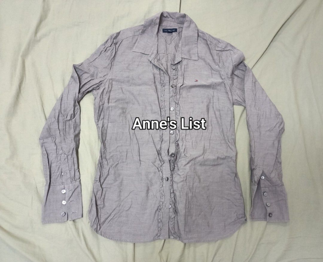 Tommy Hilfiger Ruffled Button-Down Shirt Size S-M (Category: Blouses) located in Santa Maria. Submitted by anne_s.list (Listing ID 1464831882, Image 1). Description: - Brand: Tommy Hilfiger - Style: Long sleeve button-down with front ruffle detail and classic collar - Color: Greyish-brown - Material: 100% Cotton - Fit/Sizing: Chest width measures 16 inches (model is 5'2" for reference) - Policy: Strictly no return, no exchange RFS : Letting go of