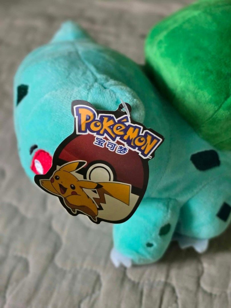 Tomy Pokémon Bulbasaur Plush Toy with Tags (Category: Plushies & Soft Toys) located in Baguio. Submitted by je_ver_lyn16 (Listing ID 1464846137, Image 2). Description: - Authentic Tomy Bulbasaur plush toy - Measures ~5.5 inches tall - Made with soft fabric, bright green bulb, and embroidered face/spots - Complete with original hang tag and side cloth tag - Perfect for Pokémon collectors and fans.