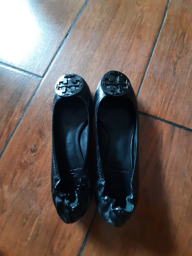 Tory Burch Flats (Category: Flats & Sandals) located in Castillejos. Submitted by lalainecloset22 (Listing ID 1464783831, Image 2). Description: - Brand: Tory Burch - Style: Black patent leather flats with round toes - Detail: Large iconic double T logo on the front - Comfort: Slip-on design with gathered elasticized heels and flexible rubber soles - Size: US 5 - Condition: Great for daily wear or travel packing -Made in Brazil .