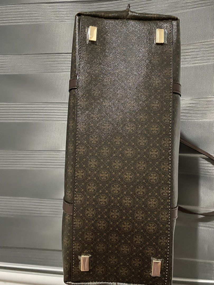 Tory Burch Monogram Tote Bag Brown (Category: Tote Bags) located in Magalang. Submitted by katoenjeru0723 (Listing ID 1464881280, Image 3). Description: - Brand: Tory Burch - Color/Design: Brown monogram print with structured silhouette - Hardware: Gold-tone with protective metal feet at the base - Straps: Dual shoulder straps with brown leather trim - Closure: Secure top zipper - Interior: Custom patterned lining with a convenient snap-flap pock