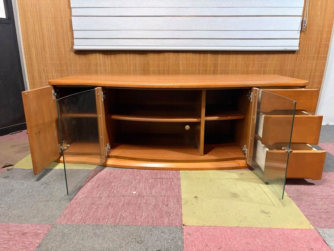 Tv Rack UpTo 65" (Category: TV Consoles) located in Meycauayan. Submitted by marygracecasimiro (Listing ID 1464822996, Image 2). Description: 😍SUPER SOLID WOOD!!! Elegant Curved Wooden Long Tv Rack CURVED GLASS!!! VERY HEAVY!!! ANGGANDA!!! UPTO 65-INCH TV!!! MAKINIS!!! This is a classic curved wooden TV stand featuring a central glass-paneled cabinet, a side cabinet, and three drawers on the right. Price : 11,900 ✅ *SEE VIDEO COMMENT 57L x 22W x