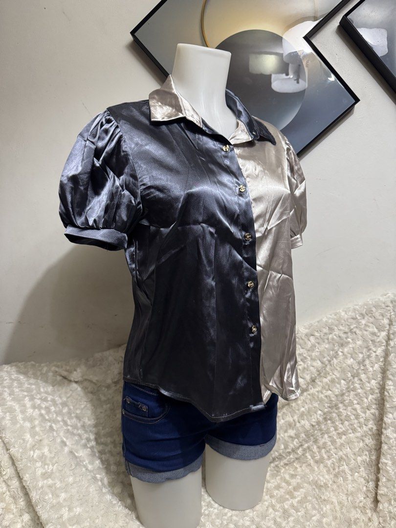 Two-tone Satin Short Sleeve Button-Down Blouse (Category: Blouses) located in Marikina City. Submitted by lorradel (Listing ID 1464905779, Image 2). Description: - Two-tone split design: dark grey and champagne gold - Short puff sleeves with comfortable elastic cuffs - Classic collared neck with chic gold-tone front buttons - Luxurious smooth satin fabric with a subtle sheen - Perfect for smart-casual or dressed-up looks - MAY HAVE some washable 